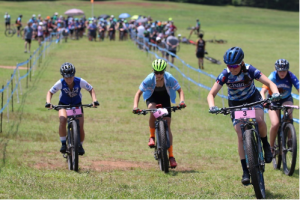 Decker [foreground, right] starts a race in the North Carolina Interscholastic Cycling League. She would go on to win this race, beating her second-place opponent by 17 seconds.