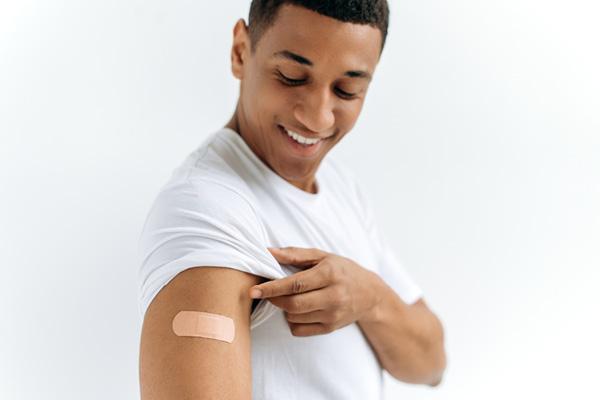 Man looking at arm at vaccination site 