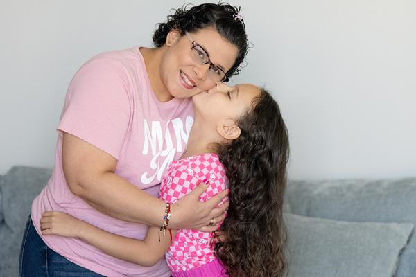 Eliana with her daughter embracing at home 