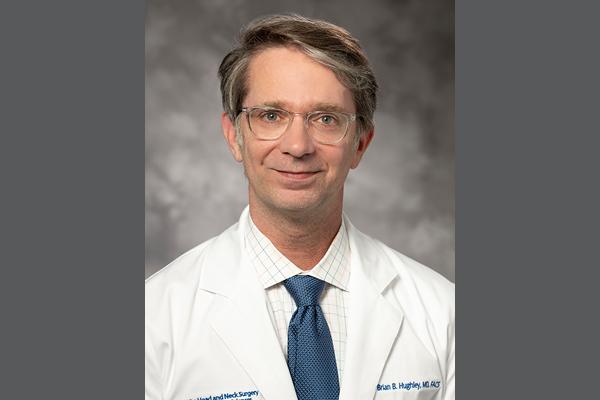 Headshot of Dr. Hughley on gray background