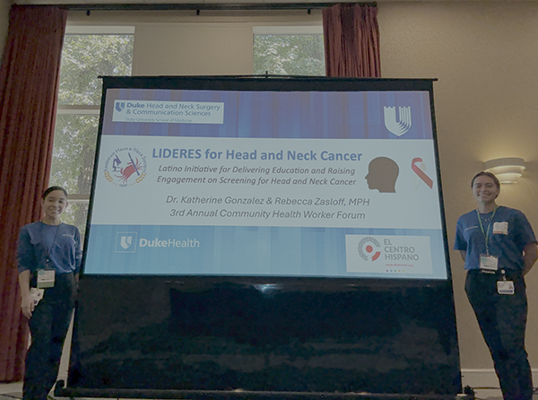 Two people beside a presentation