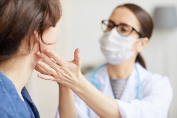 iStock image: Physician checking glands under patients chin