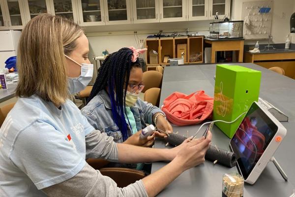 Volunteer and child in front of computer screen