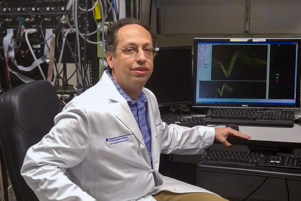 Dr. Steven Eliades, Associate Professor of HNS&CS, sits at a computer while conducting research analysis.