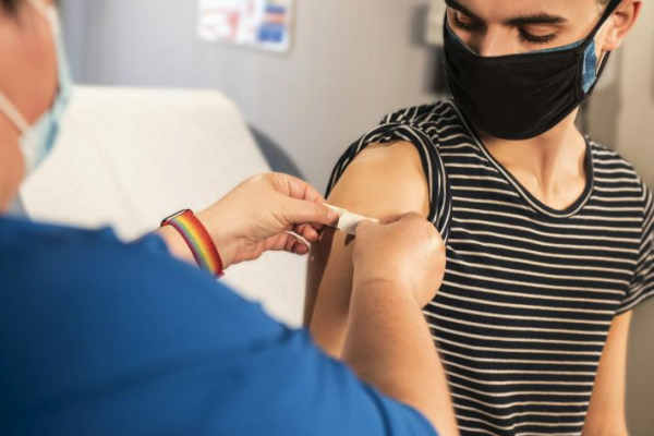 Young man receiving band-aid after vaccine