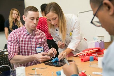 Morgan L. Cox, MD, demonstrates suturing techniques to medical students in the Surgery Technique and Review (STAR) Course.