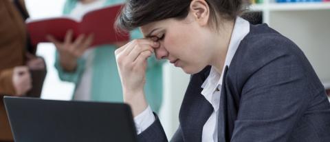 Office worker looking exasperated pinching her nose