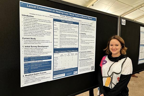 Jessie West in front of poster at American Auditory Society Conference