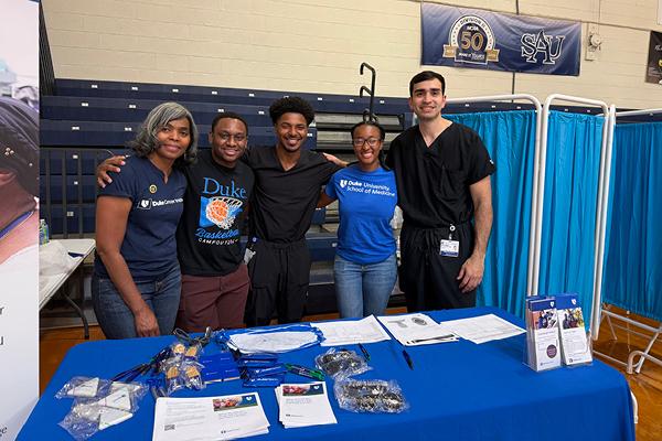 HNS&CS team behind a table at a Head and Neck Screening Event