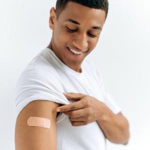 Man looking at arm at vaccination site 