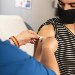 Young man receiving band-aid after vaccine