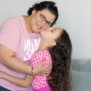 Eliana with her daughter embracing at home 