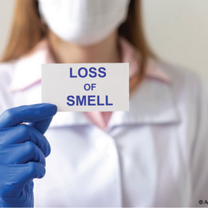 a medical provider holding a card that says: loss of smell