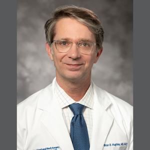 Headshot of Dr. Hughley on gray background
